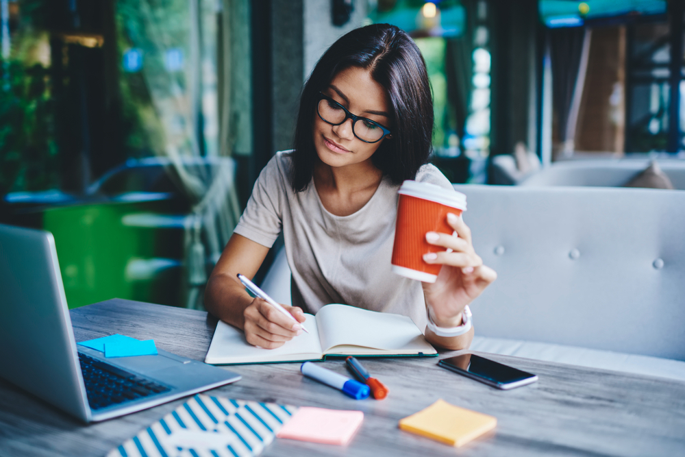 a freelancer writing on her notebook