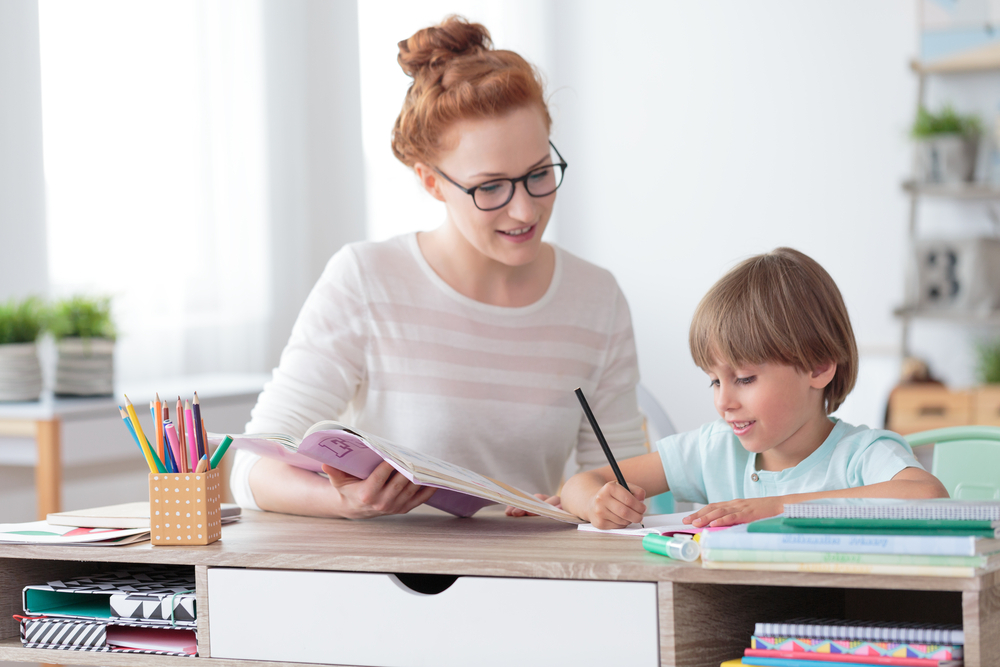 A home tutor who is happily teaching a child